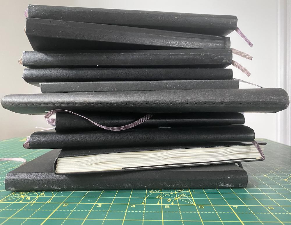 A pile of Adam Westbrook&rsquo;s finished sketchbooks